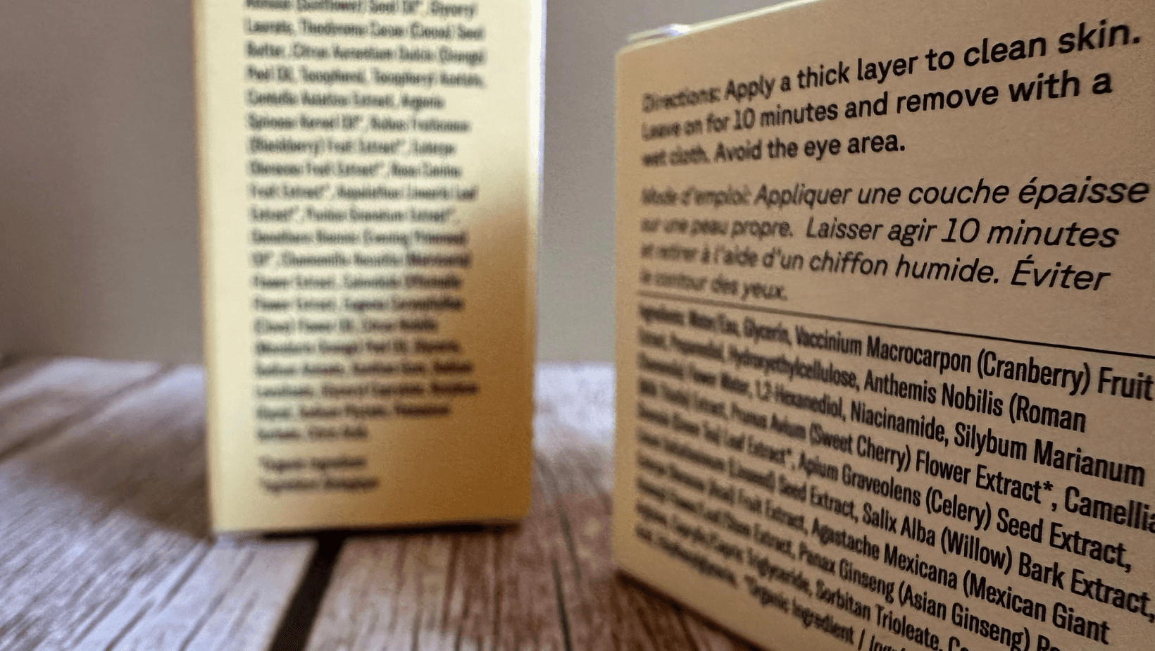 Close-up photo of skincare packaging showing detailed ingredient lists printed on yellow boxes, symbolizing transparency and clean beauty labeling.